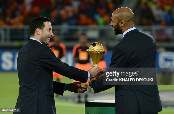 Malian forward Frederic Kanoute and Egyptian midfielder Mohamed Aboutrika deliver the 2015 African Cup of Nations trophy ahead of the final football...