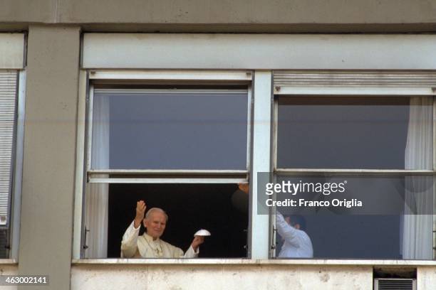 Pope John Paul II waves from the window of his room at the 'Agostino Gemelli' Hospital, as he shows his biretta, after undergoing an emergency...