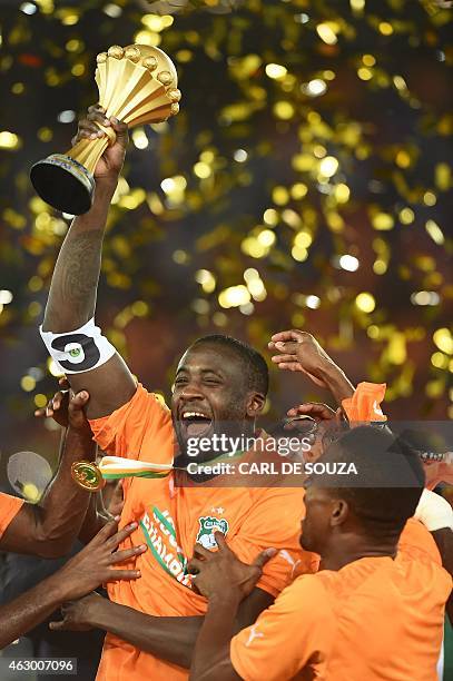 Ivory Coast's midfielder Yaya Toure raises the trophy as he celebrates with teammates after winning the 2015 African Cup of Nations final football...