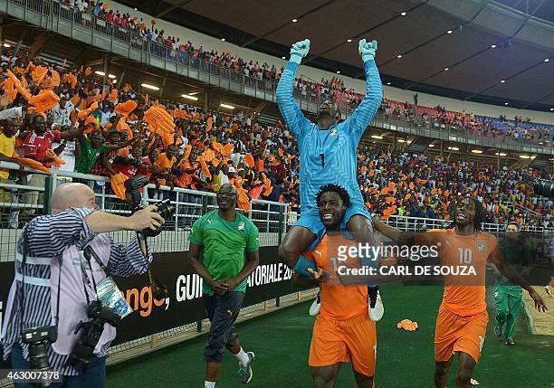 Ivory Coast's forward Wilfried Bony carries goalkeeper Boubacar Barry on his shoulders as they celebrate with forward Gervinho after winning the 2015...
