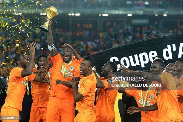 Ivory Coast's midfielder Yaya Toure raises the trophy at the end of the 2015 African Cup of Nations final football match between Ivory Coast and...
