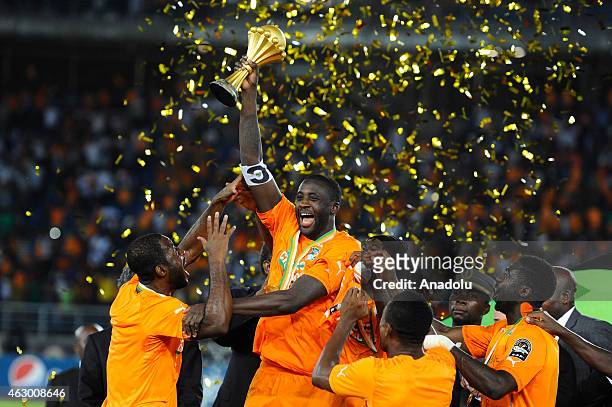 Ivory Coast's Yaya Toure holds up the trophy as he celebrates with his teammates after winning the 2015 African Cup of Nations final soccer match...