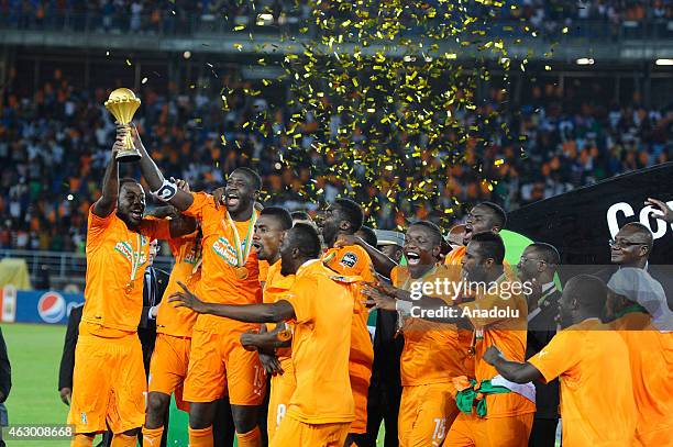 Ivory Coast's Yaya Toure holds up the trophy as he celebrates with his teammates after winning the 2015 African Cup of Nations final soccer match...