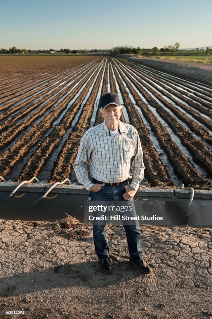 Caucasian farmer standing in irrigated field