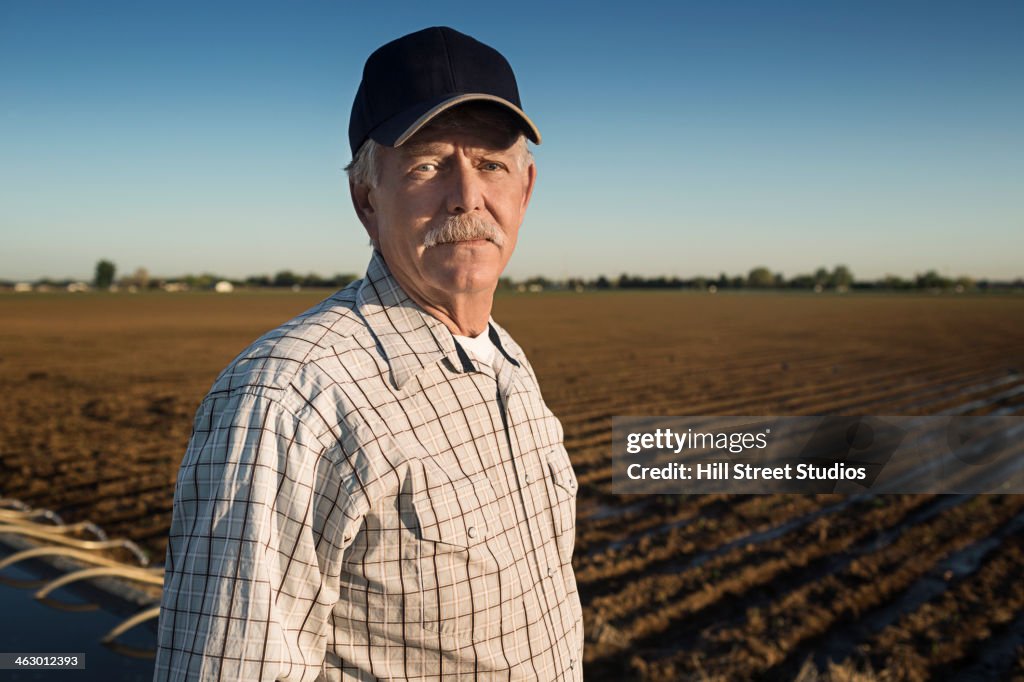 Caucasian farmer standing in irrigated field