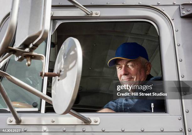 caucasian trucker sitting in semi-truck - old truck stock-fotos und bilder