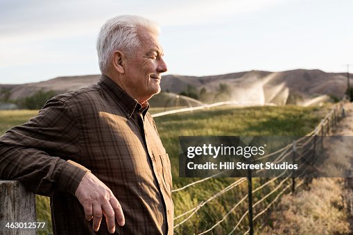 Caucasian farmer looking over fields Caucasian farmer looking over fields