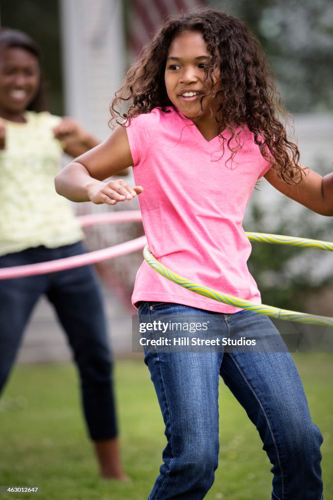 Girls hula hooping in backyard