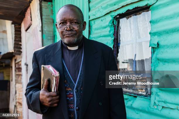 black priest carrying bible - senior pastor stockfoto's en -beelden