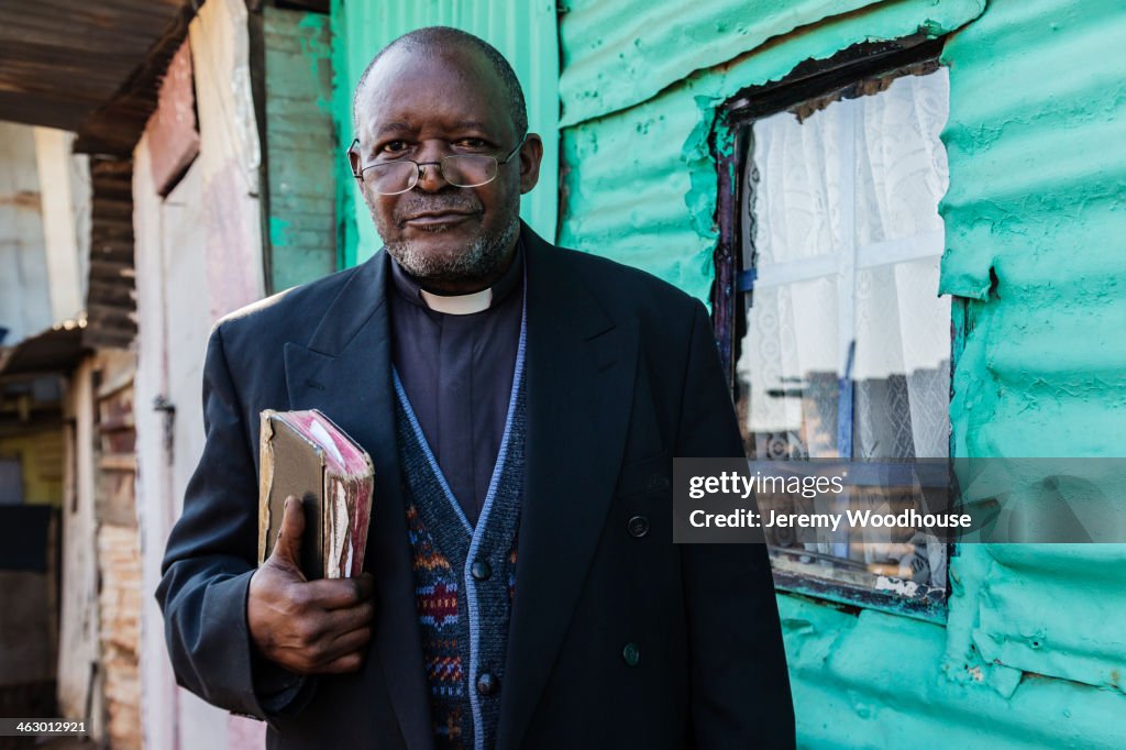 Black priest carrying bible