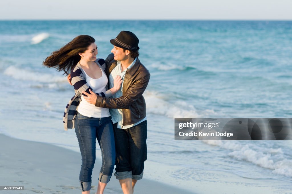 Hispanic couple walking on beach