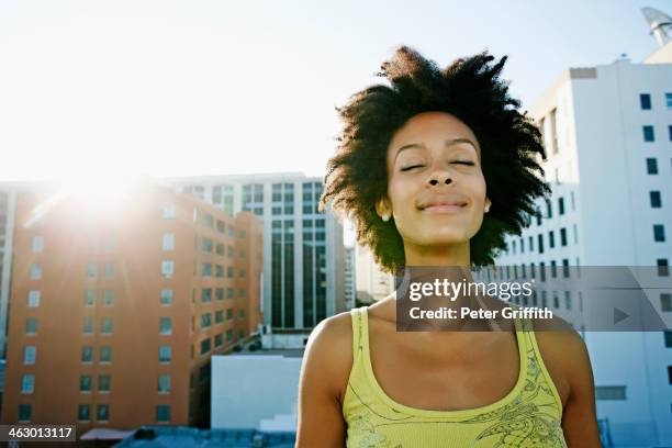 mixed race woman on urban rooftop - natuurlijk haar stockfoto's en -beelden