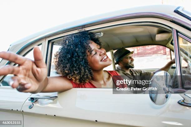 couple driving in vintage car - woman with arms outstretched stock pictures, royalty-free photos & images