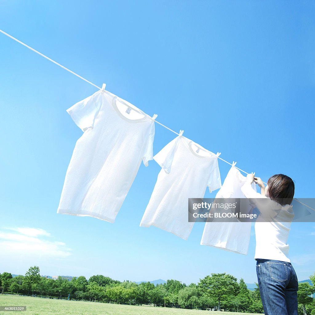 Woman Hanging Clothes On Washing Line