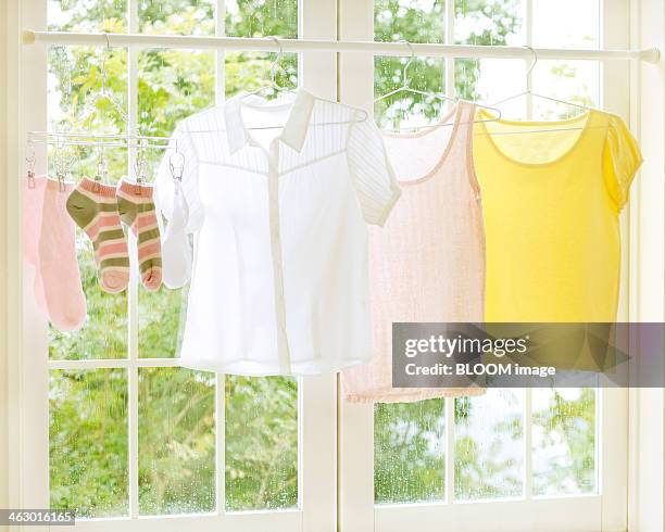 laundry drying near the window - tシャツ　無人 ストックフォトと画像