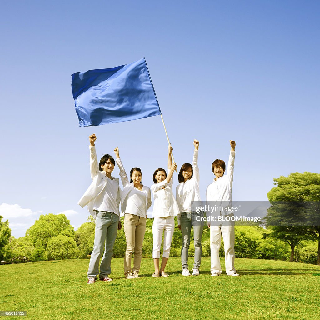 Group Of Friends Raising Hand With Flag