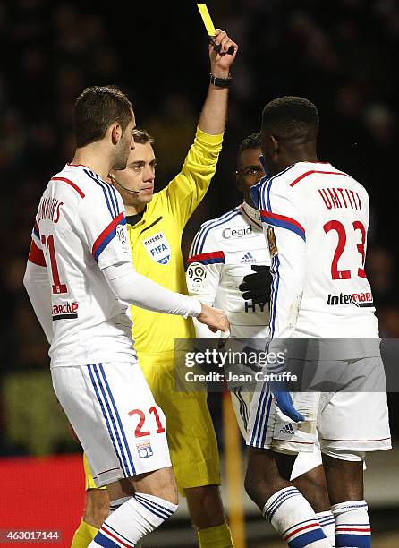 Referee Clement Turpin delivers a yellow card to Samuel Umtiti of Lyon during the French Ligue 1 match between Olympique Lyonnais and Paris...