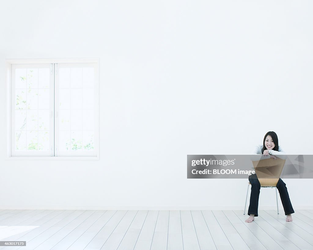 Young Woman Sitting On Chair In  Empty Room