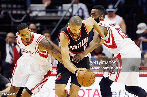Nicolas Batum of the Portland Trail Blazers drives with the ball against Trevor Ariza and James Harden of the Houston Rockets during their game at...