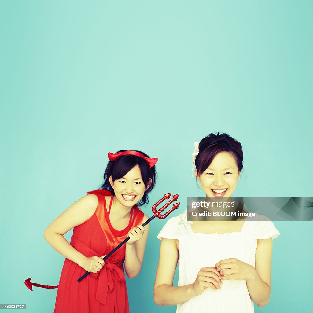 Happy Young Women Dressed As Devil And Angel