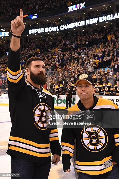 Rob Ninkovich and President Jonathan Kraft of the New England Patriots acknowledge the crowd from the ice before the game of the Boston Bruins...