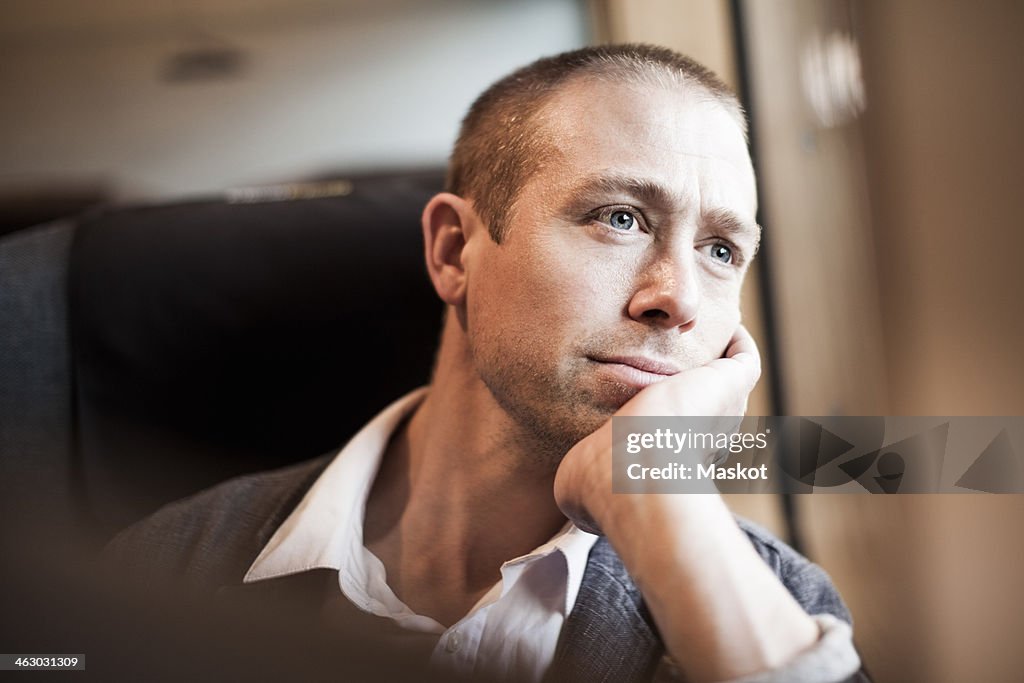 Thoughtful mature businessman sitting in train