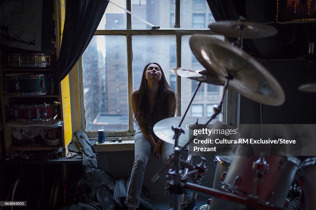 Young woman on window seat of New York apartment