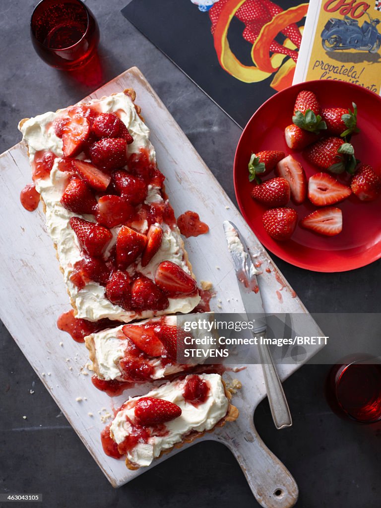 Still life of strawberry jam tart sliced on chopping board