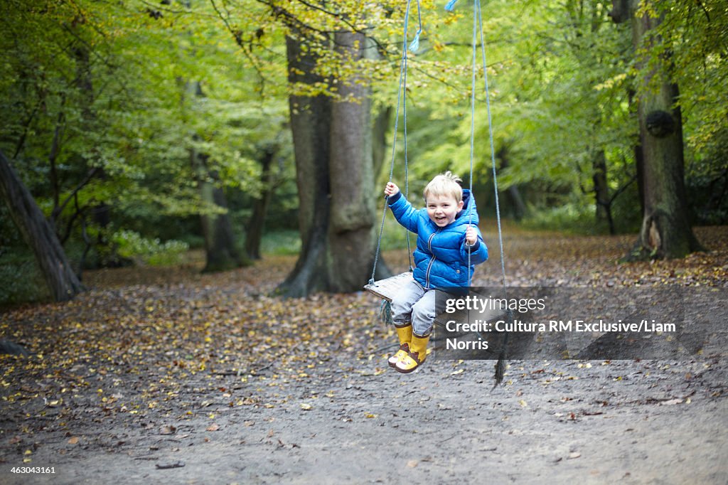 Boy on swing in forest