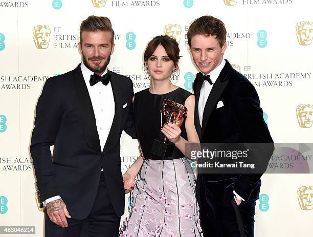 Presenter David Beckham poses with Felicity Jones and Eddie Redmayne with the Outstanding British Film award for 'The Theory Of Everything' in the...