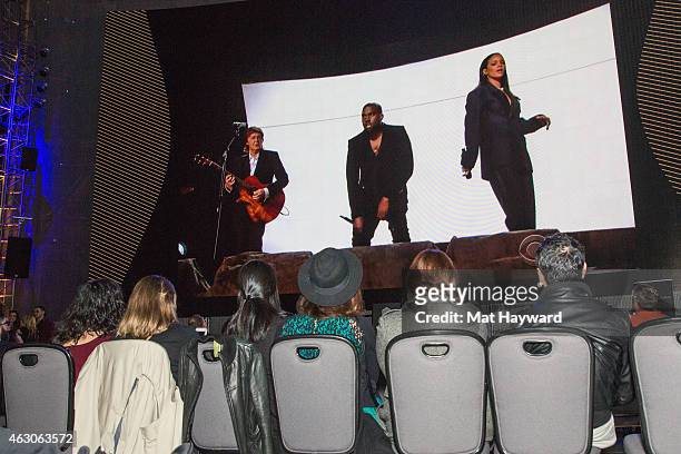 Guests watch as Paul McCartney, Rihanna and Kanye West perform on screen during the PNW Chapter 57th GRAMMY Awards Telecast Party at Experience Music...