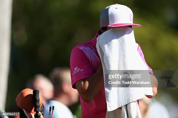 Rickie Fowler wipes his face at the seventh hole at La Quinta Country Club Course during the first round of the Humana Challenge in partnership with...
