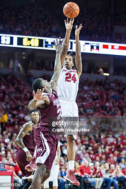 Michael Qualls of the Arkansas Razorbacks shoots a jump shot over Travis Daniels of the Mississippi State Bulldogs at Bud Walton Arena on February 7,...