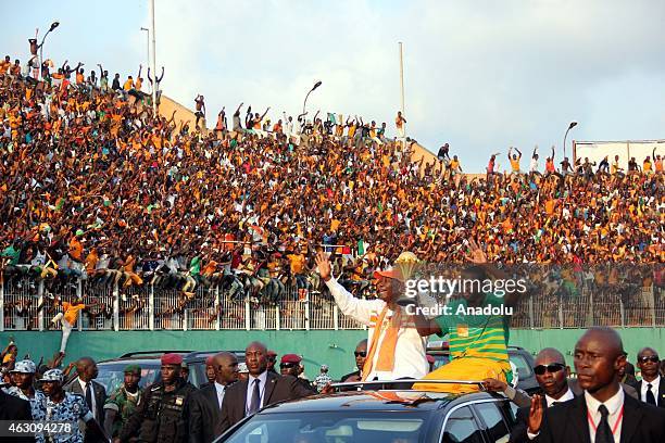 Ivory Coast's President Alassane Ouattara and Ivory Coast's national football team captain Yaya Toure wave to the crowd during a welcoming ceremony...