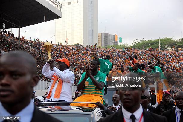 Ivory Coast's President Alassane Ouattara and Ivory Coast's national football team captain Yaya Toure wave to the crowd during a welcoming ceremony...