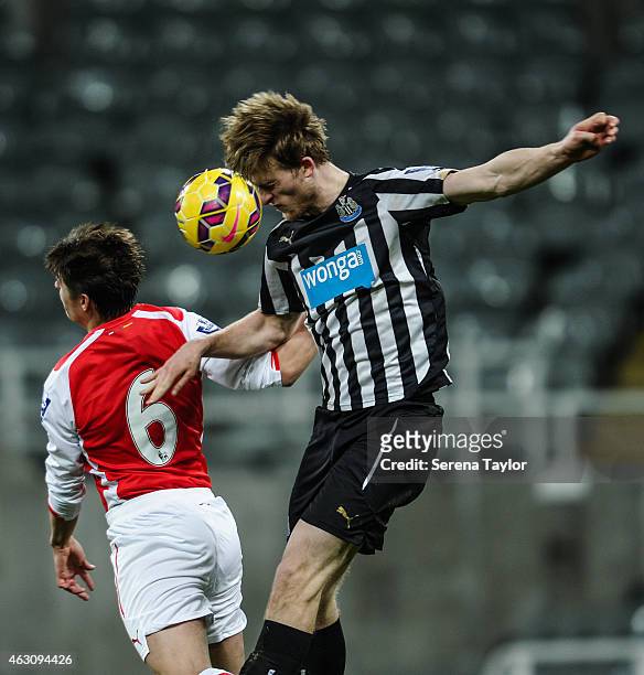 Tom Heardman of Newcastle wins a header whilst being challenged by George Dobson of Arsenal during the U21 Barclays Premier League match between...
