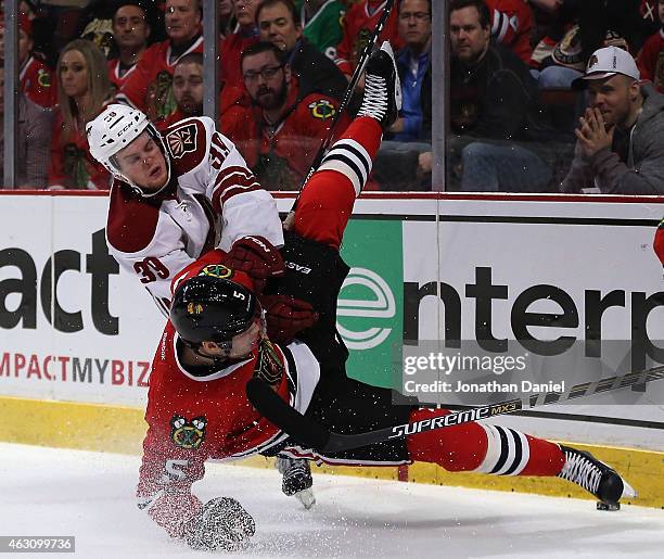 Brendan Shinnimin of the Arizona Coyotes dumps David Rundblad of the Chicago Blackhawks at the United Center on February 9, 2015 in Chicago, Illinois.