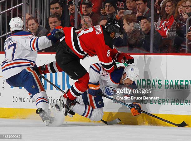 Dainius Zubrus of the New Jersey Devils and Matt Hendricks of the Edmonton Oilers collide along the boards during the third period at the Prudential...