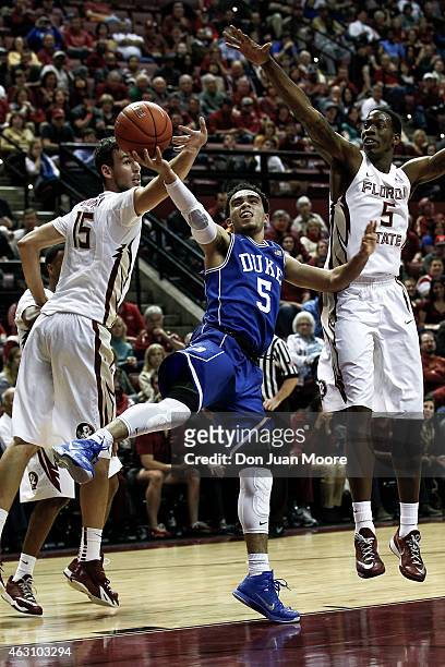 Tyus Jones of the Duke Blue Devils shoots over Boris Bojanovsky and Jarquez Smith of the Florida State Seminoles during the game at the Donald L....