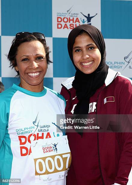 Dame Kelly Holmes of Great Britain and Qatari athlete, Mariam Farid pose for a picture during the Dolphin Energy Doha Dash at Losail Circuit on...