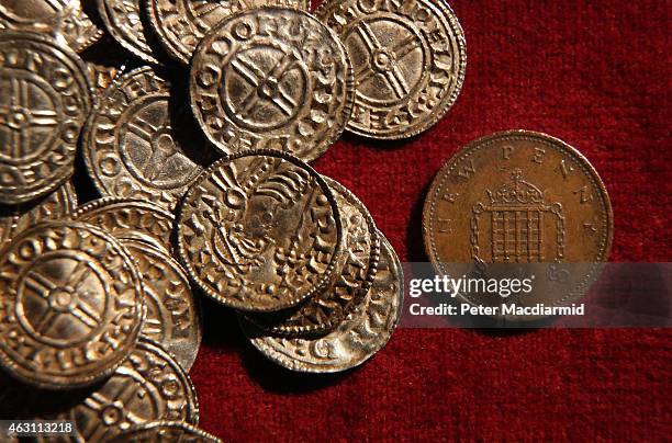 Modern day one pence coin is displayed with Anglo Saxon silver pennies at The British Museum on February 10, 2015 in London, England. Rare coins and...