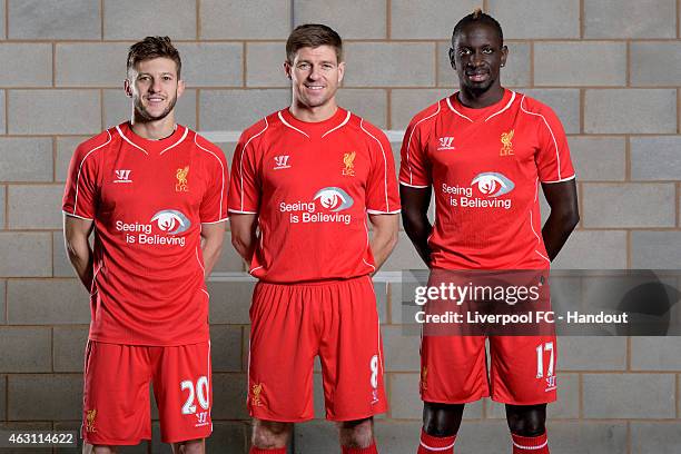 In this handout image provided by Liverpool FC, Adam Lallana, Steven Gerrard and Mamadou Sakho pose wearing the Liverpool shirt with the new logo...