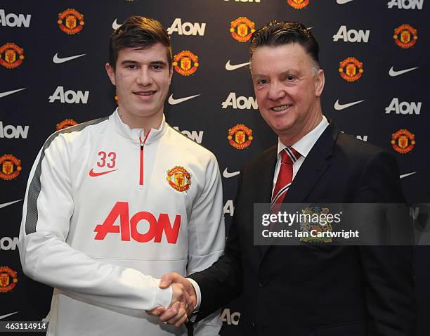 Patrick McNair of Manchester United shakes hands with Manchester United Manager Louis van Gaal after signing an extension to his playing contract at...