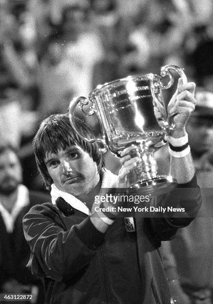 Jimmy Connors holds cup with one hand and waves to crowd with the other after beating Czech ace Ivan Lendl, 6-3, 6-2, 4-6, 6-4, to win the U.S. Open...