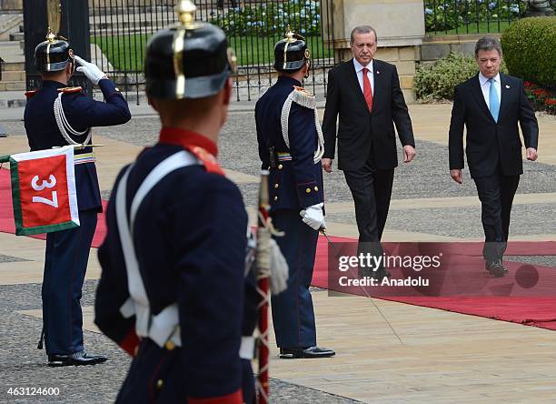 Turkey's President Recep Tayyip Erdogan and Colombian President Juan Manuel Santos review honor guard at Narino Palace in Bogota on February 10,...