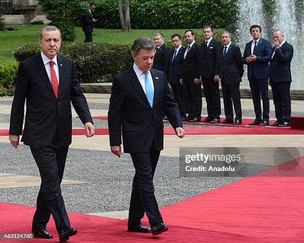 Turkey's President Recep Tayyip Erdogan and Colombian President Juan Manuel Santos review honor guard at Narino Palace in Bogota on February 10,...