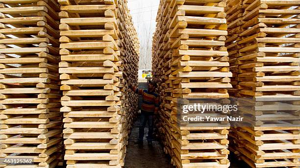 Worker counts stacks of willow cleft used to make cricket bats at a factory on February 10, 2015 in Halmullah, 50 km south of Srinagar, the summer...