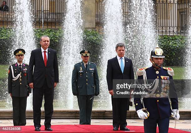 Turkey's President Recep Tayyip Erdogan and Colombian President Juan Manuel Santos review honor guard at Narino Palace in Bogota on February 10,...