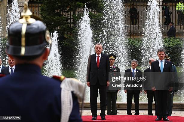 Turkey's President Recep Tayyip Erdogan and Colombian President Juan Manuel Santos review honor guard at Narino Palace in Bogota on February 10,...