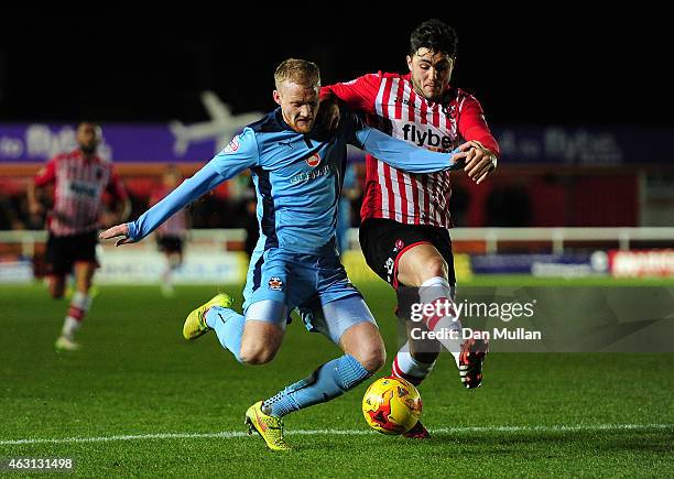 Robbie Simpson of Cambridge United battles for the ball with Jordan Moore-Taylor of Exeter City during the Sky Bet League Two match between Exeter...